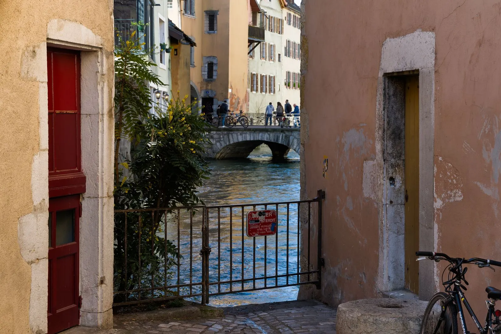 Ruelle de la vieille ville d'Annecy ouvrant sur un pont de pierre au-dessus du Thiou