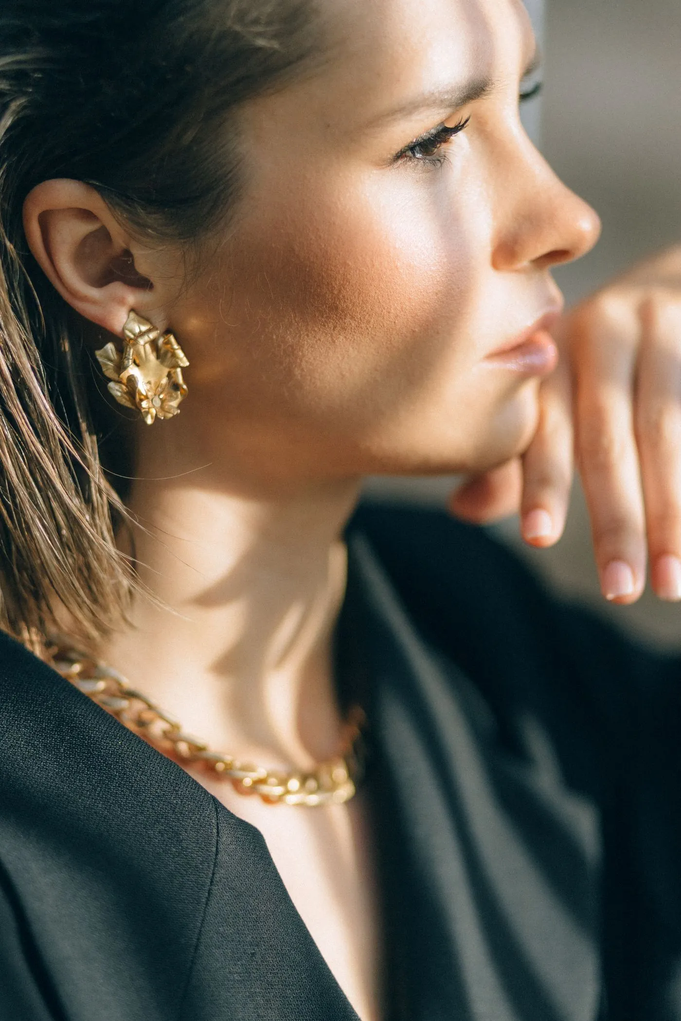 Femme portant des boucles d'oreilles et un collier dorés