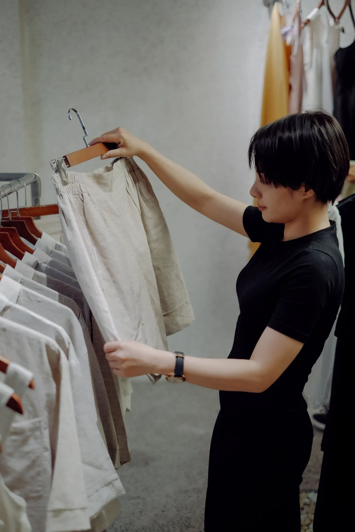 Jeune femme regardant des vêtements dans une boutique minimaliste
